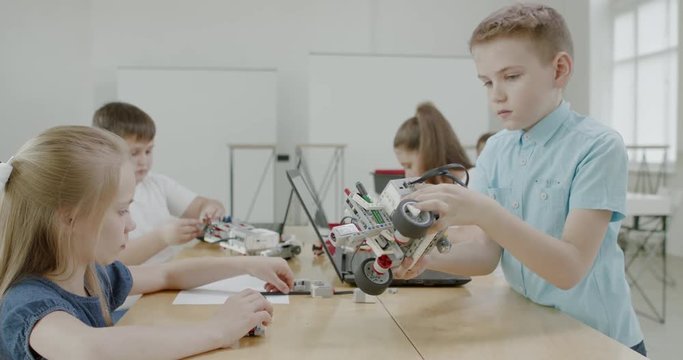 Curious kids working on a functional programable robot during robotics class at school. 4K UHD 60 FPS SLOW MOTION
