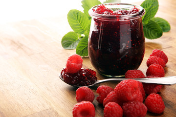 raspberry jam with fresh raspberries and mint. marmalade on spoon and jar