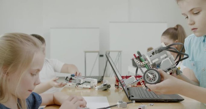 Curious kids working on a functional programable robot during robotics class at school. 4K UHD 60 FPS SLOW MOTION