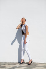 Model tests. Young beautiful brunette model posing against a white wall