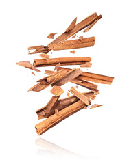 Cinnamon sticks fall down close up, isolated on white background