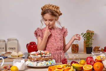Little girl is making a homemade cake with an easy recipe at kitchen against a white wall with shelves on it.