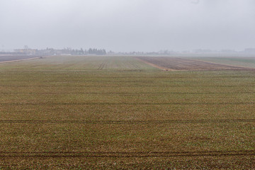 Fototapeta na wymiar cultivated fields in countryside with dark and wet soil for agriculture.