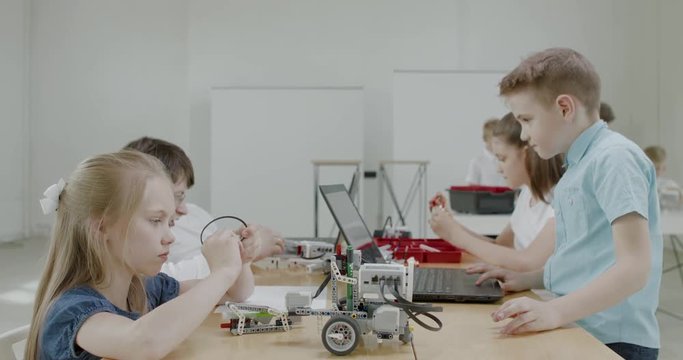 Curious kids working on a functional programable robot during robotics class at school. 4K UHD 60 FPS SLOW MOTION