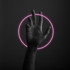 Male open hand gesture on a dark background with abstract neon light glow