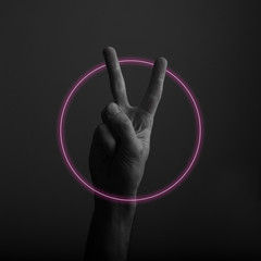 Male hand showing victory V hand sign with abstract neon light glow