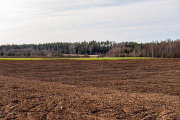 cultivated fields in countryside with dark and wet soil for agriculture.