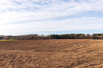 Obraz premium cultivated fields in countryside with dark and wet soil for agriculture.