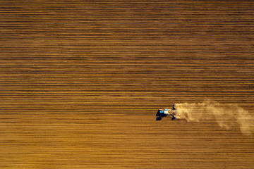 Tractor in field on a farm, aerial view