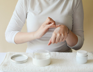 Obraz na płótnie Canvas young woman applying a white cream for skin