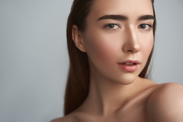 Naklejka premium Tranquil young woman is against grey background