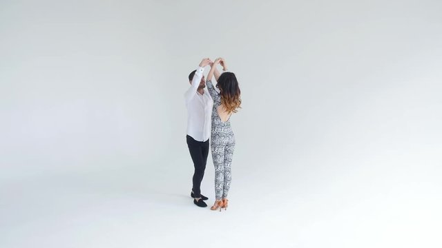 Concept of love, relationships and social dancing. Beauty young couple dancing social dance on white background