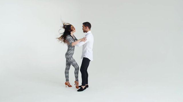 Concept of love, relationships and social dancing. Beauty young couple dancing social dance on white background