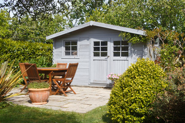 Shed with terrace and wooden garden furniture in a garden during spring - 270475854