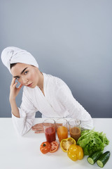 Lady relaxing with fresh juices after bath against grey background