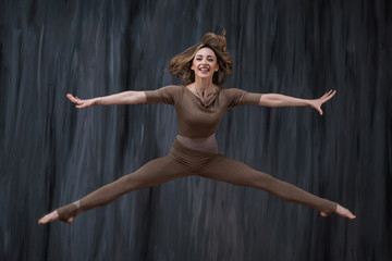 Twine in a jump. Young woman gymnast, fitness and stretching trainer shows sport exercises