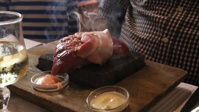 meat with smoke on stone with sauces in restaurant