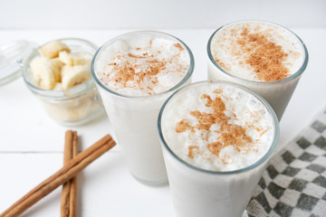 Banana smothie or milkshake with cinnamon on white  background