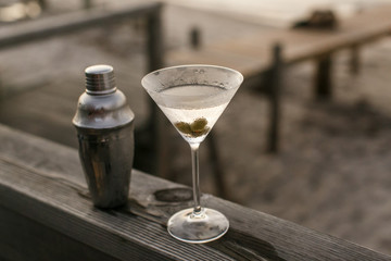Martini And Shaker Sitting On A Wooden Railing