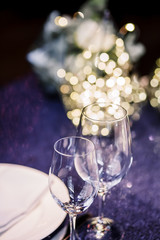 Table decoration with fresh flowers in pastel colors. Elegant dining table in peach-lilac color. Luxurious composition. Indoors wedding. Beautiful table setting.  Photos from the side.