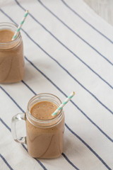 Healthy banana apple smoothie in glass jars, low angle view. Copy space.