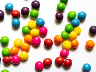 Top view of colorful candies on white background.