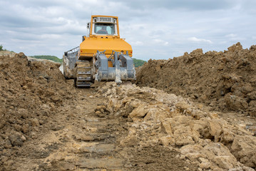Obraz premium Bulldozer moving marl and limestone over the quarry edge