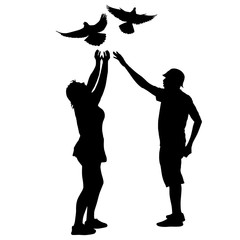 Silhouette of a guy and a girl letting go of the dove into the sky