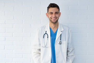 portrait of young doctor smiling on white background