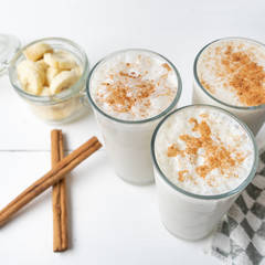 Banana smothie or milkshake with cinnamon on white  background