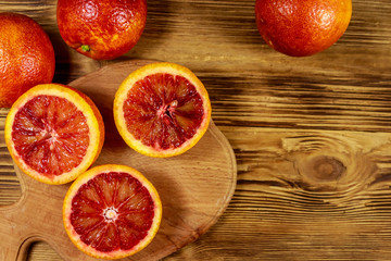 Red blood oranges on wooden table. Top view