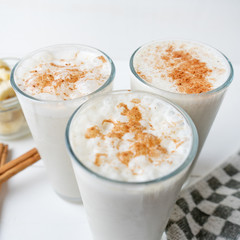 Banana smothie or milkshake with cinnamon on white  background