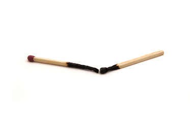 two burnt matches on a white background