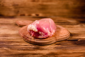 Cutting board with raw chicken fillet on wooden table