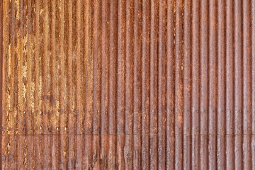 Rusty sheet of corrugated metal wall, as a textured background