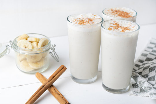 Banana smothie or milkshake with cinnamon on white  background