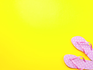Top view image of pink flip flops on yellow background. Summer trevel and vacation concept