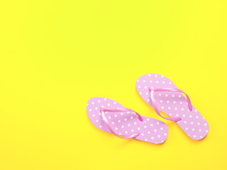 Top view image of pink flip flops on yellow background. Summer trevel and vacation concept