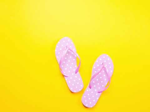 Top view image of pink flip flops on yellow background. Summer trevel and vacation concept