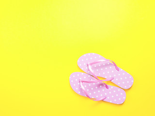 Top view image of pink flip flops on yellow background. Summer trevel and vacation concept