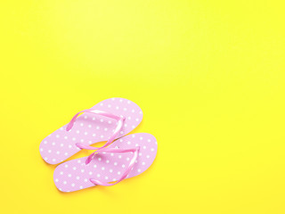 Top view image of pink flip flops on yellow background. Summer trevel and vacation concept