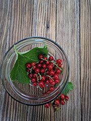 red currants and glass bowl on wooden table
