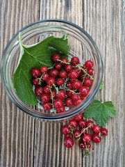 red currants and glass bowl on wooden table