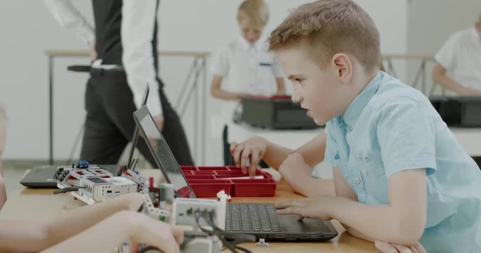 Curious kids working on a functional programable robot during robotics class at school. 4K UHD 60 FPS SLOW MOTION