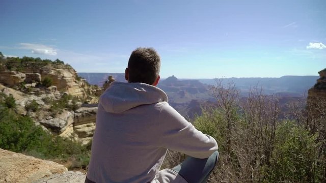 Man walking in Grand Canyon near cliff