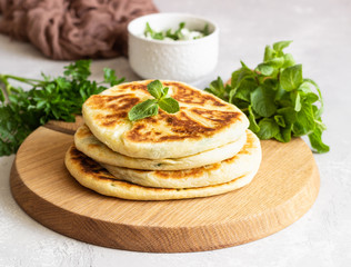 Frying flatbread filled with fresh herbs and cheese. Khychiny or qutab - traditional caucasian or Azerbaijani flatbread