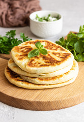 Frying flatbread filled with fresh herbs and cheese. Khychiny or qutab - traditional caucasian or Azerbaijani flatbread