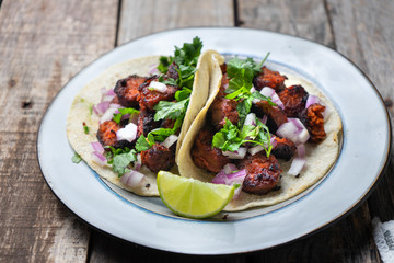 Mexican food: Delicious red chorizo tacos on wooden background
