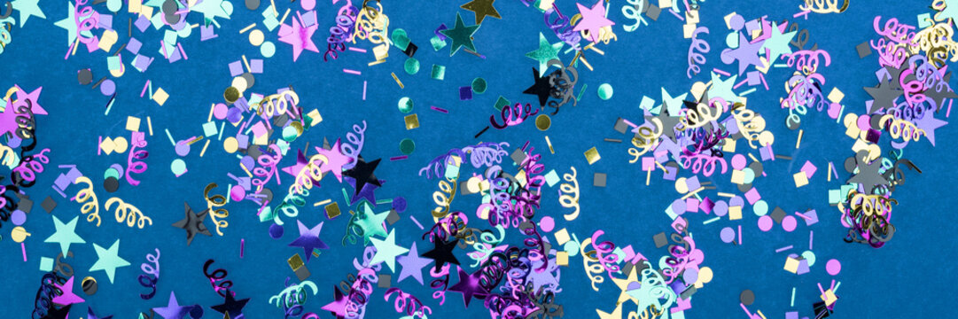 Panoramic shot of colorful confetti on blue party background