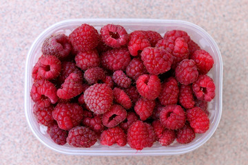 Package full of freshly picked raspberries. Top view.
